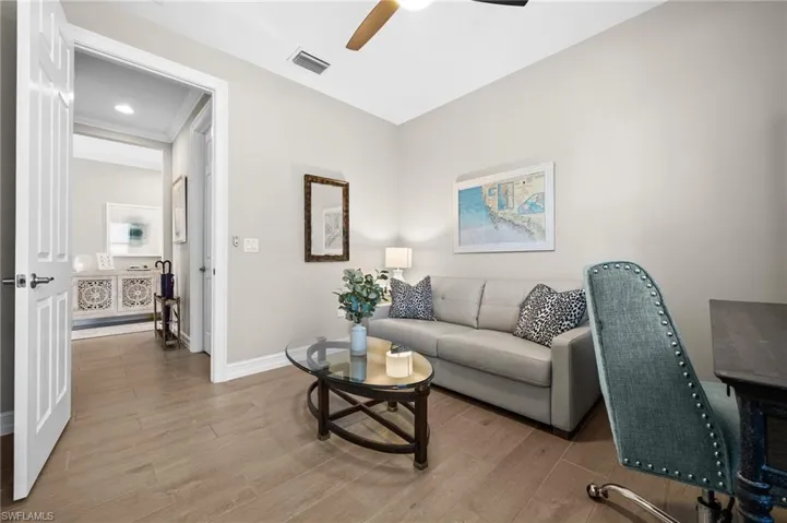 Living room with ceiling fan and light hardwood / wood-style floors