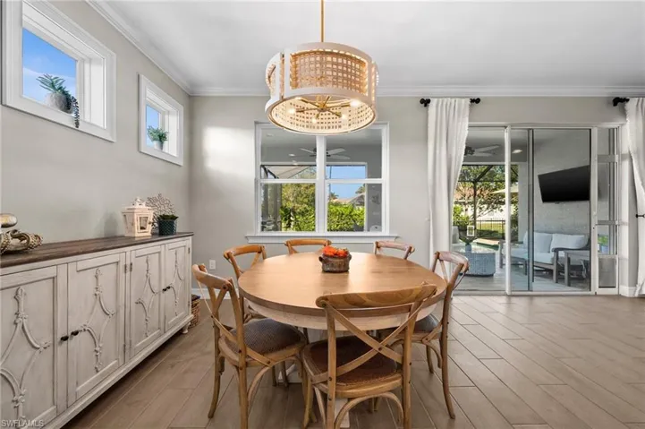 Dining area with a chandelier, crown molding, and light hardwood / wood-style flooring