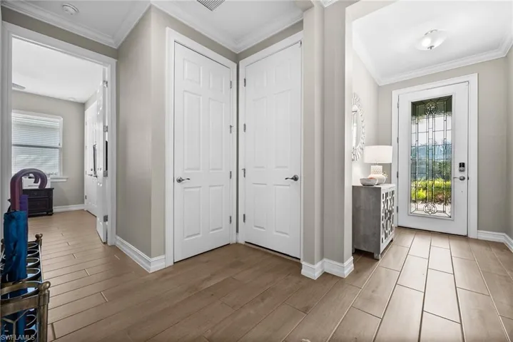 Entrance foyer with light hardwood / wood-style flooring, a healthy amount of sunlight, and ornamental molding