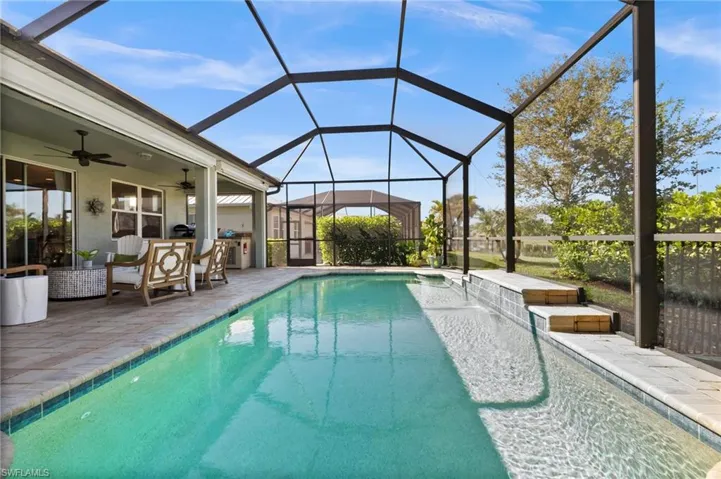 View of swimming pool with a patio, glass enclosure, and ceiling fan