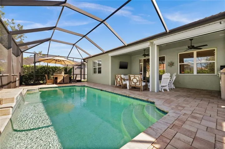 View of swimming pool featuring an outdoor hangout area, a lanai, pool water feature, ceiling fan, and a patio area