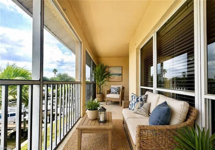 Screened balcony featuring water access, white window frames, and horizontal blinds