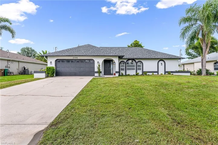 Ranch-style house with a garage, a front yard, and central AC unit