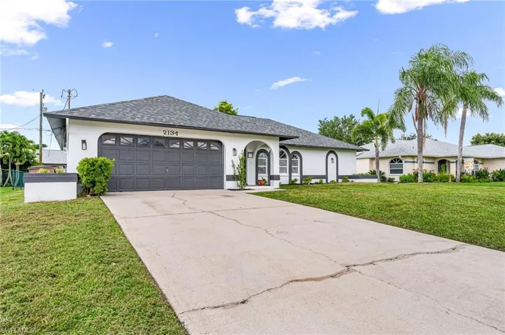 Ranch-style home with a front lawn and a garage