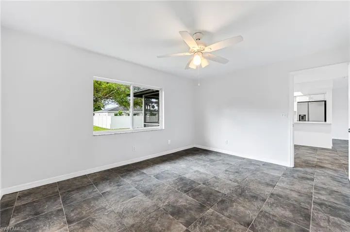 Tiled empty room featuring ceiling fan