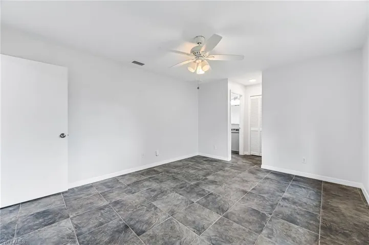 Tiled empty room with ceiling fan
