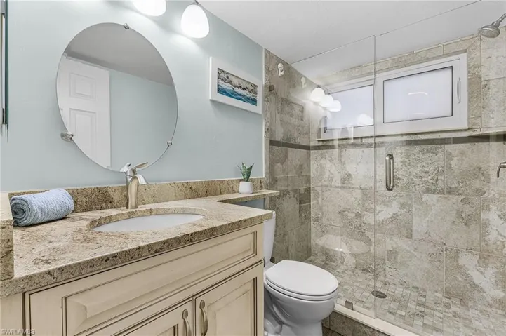 Guest bathroom with raised vanity, granite countertop and tiled shower.