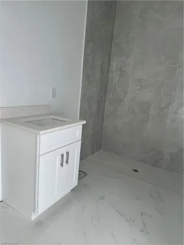 Bathroom with a tile shower and tile flooring