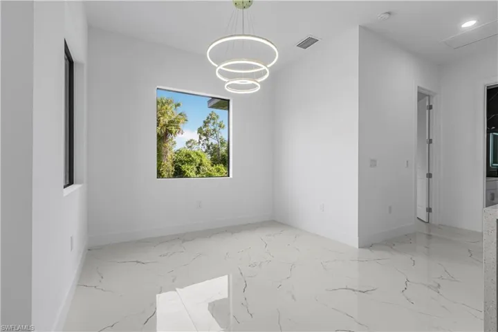 Spare room with marble tiled floors, a chandelier, recessed lighting, and a smoke detector
