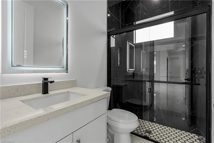 Full bath with vanity and a marble finish shower
