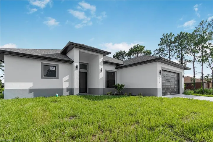 Prairie-style home featuring stucco siding, a garage, a front lawn, concrete driveway, and a shingled roof