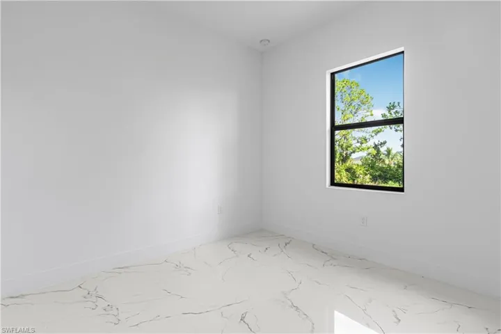 Unfurnished room with baseboards and marble finish flooring