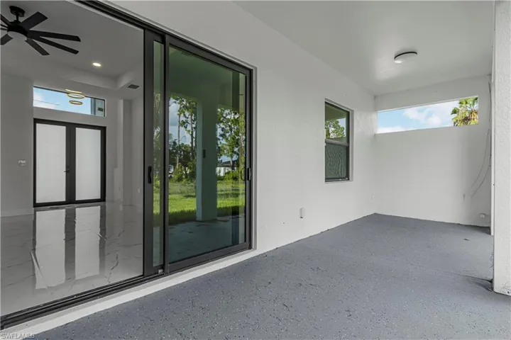 Property entrance with ceiling fan, a patio area, and stucco siding