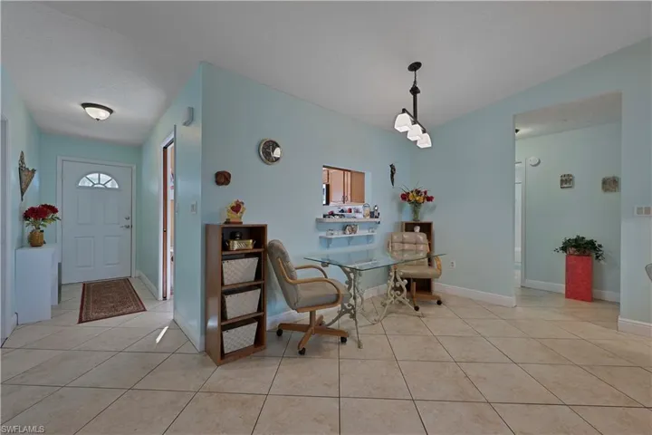 Dining area with light tile patterned floors and lofted ceiling