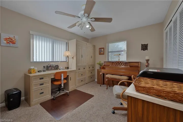 Office area featuring light carpet and ceiling fan