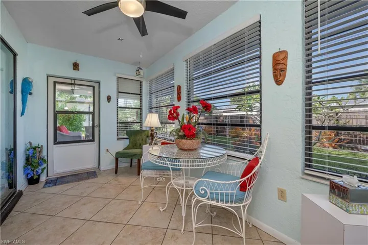 Dining area featuring a textured wall, light tile patterned floors, and a ceiling fan