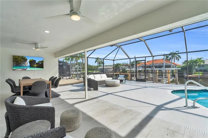 Seamless indoor-outdoor living with this spacious covered patio overlooking the pool area - Virtually Edited Image