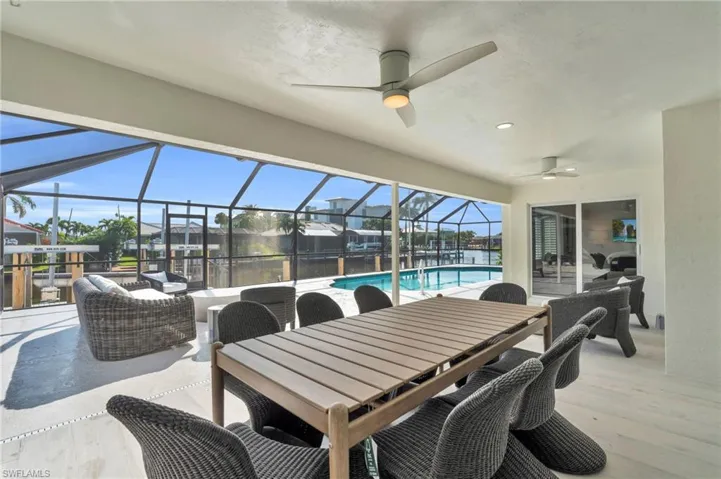 Large Covered Lanai Spacious screened lanai perfect for outdoor dining and entertaining with waterfront views - Virtually Edited Image