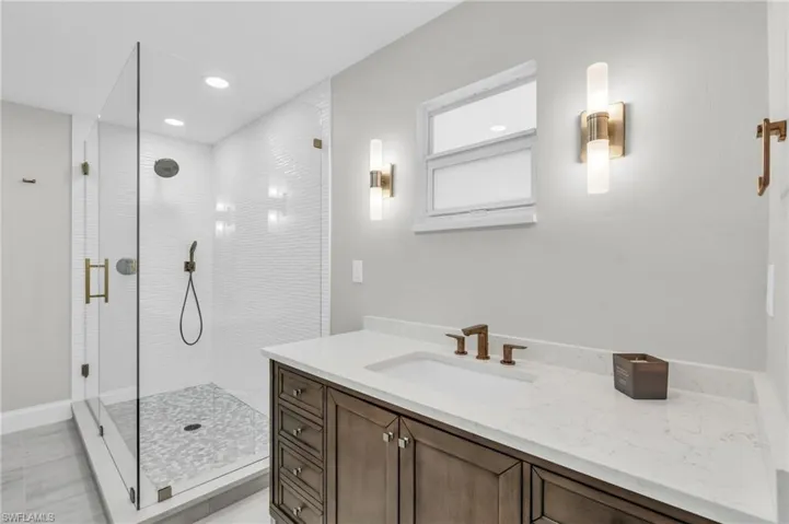 Guest Bathroom Modern bathroom featuring a glass-enclosed shower and a sleek vanity with quartz countertop - Virtually Edited Image