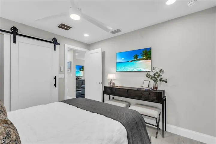 Guest Bedroom #2 Bedroom with a console table, mounted TV, and a contemporary design - Virtually Edited Image
