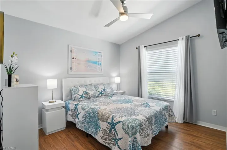 Bedroom featuring vaulted ceiling, dark wood finished floors, and a ceiling fan