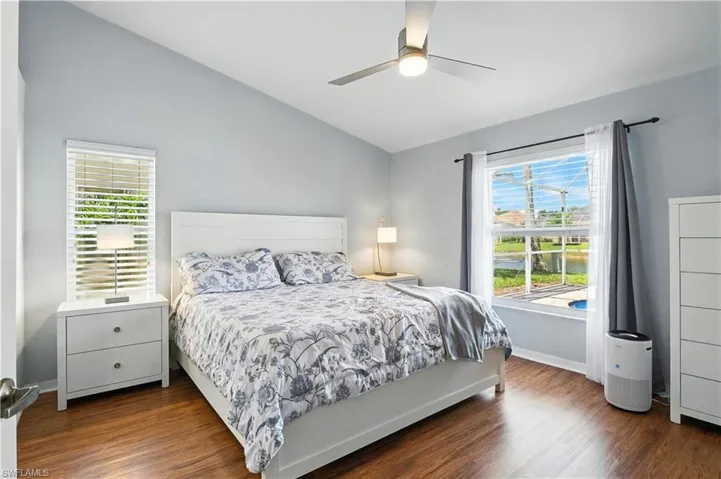 Bedroom with vaulted ceiling, wood finished floors, and ceiling fan