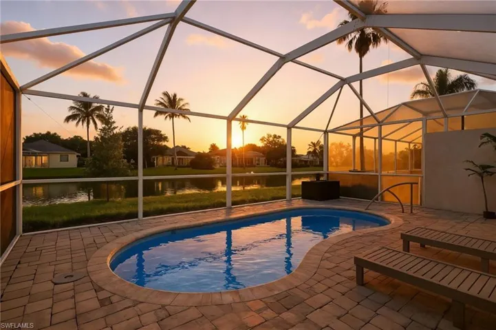 Outdoor pool featuring a sunroom, a water view, glass enclosure, and a patio