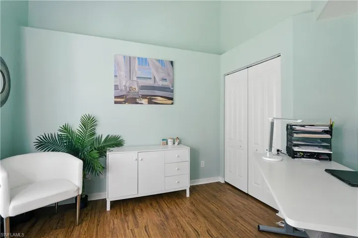 Office with dark wood-style floors and baseboards