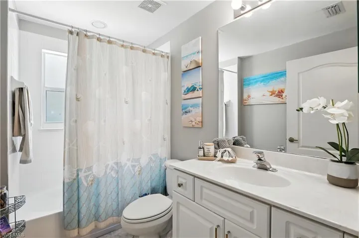 Bathroom featuring vanity and shower / bath combo with shower curtain