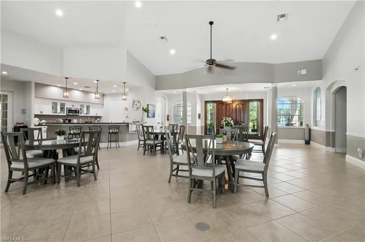Dining area with recessed lighting, ceiling fan, light tile patterned flooring, high vaulted ceiling, and arched walkways