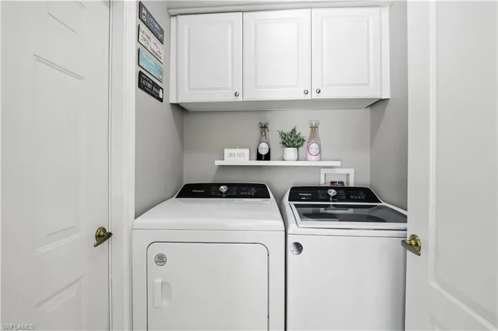 Laundry area with cabinet space and washer and clothes dryer