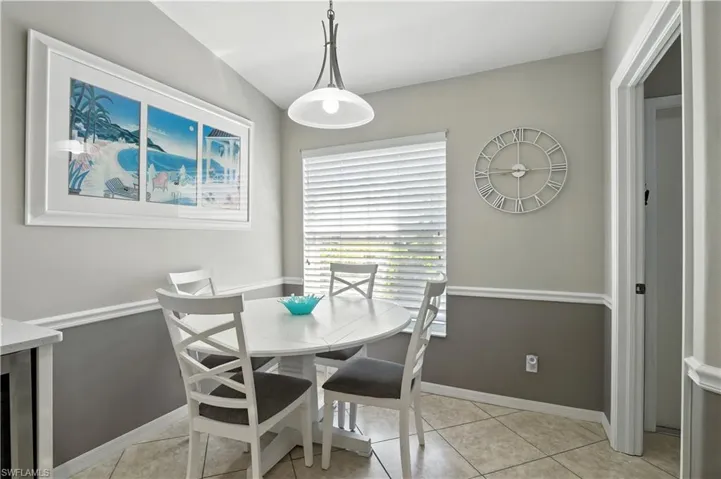 Dining space with light tile patterned floors and baseboards