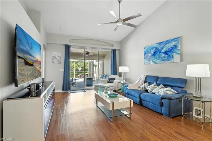 Living room featuring high vaulted ceiling, wood finished floors, and ceiling fan