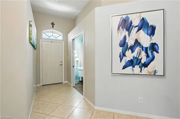 Foyer entrance featuring light tile patterned floors and baseboards