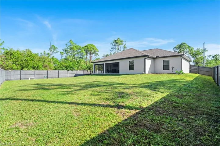 Back of house with a lawn and a sunroom