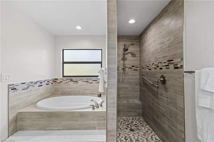 Bathroom featuring shower with separate bathtub