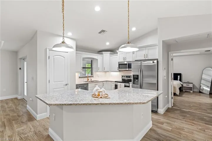 Kitchen featuring backsplash, pendant lighting, a center island, and stainless steel appliances