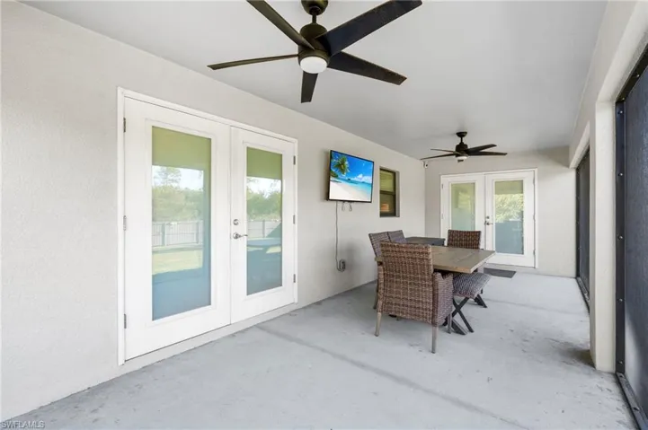 Sunroom / solarium featuring ceiling fan and french doors
