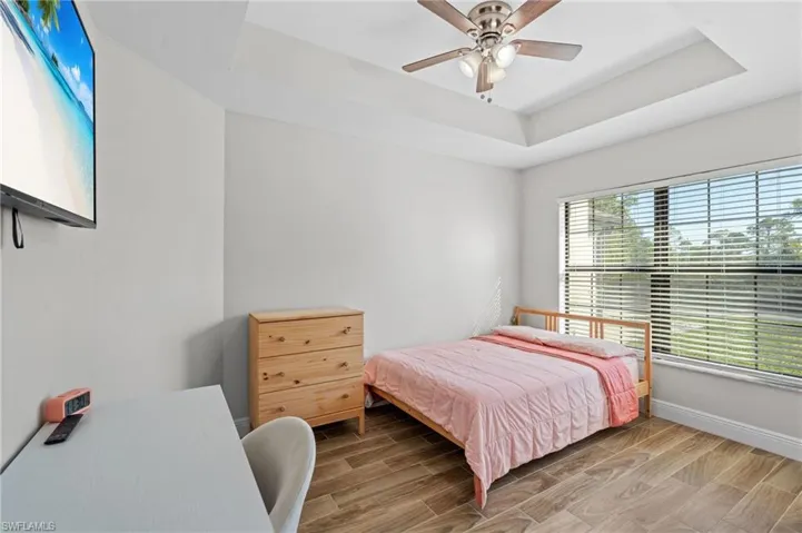 Bedroom with a tray ceiling and ceiling fan