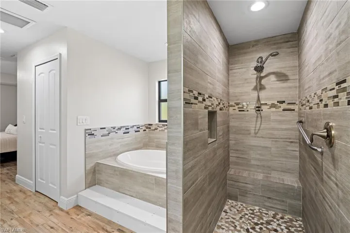 Bathroom featuring separate shower and tub and hardwood / wood-style flooring