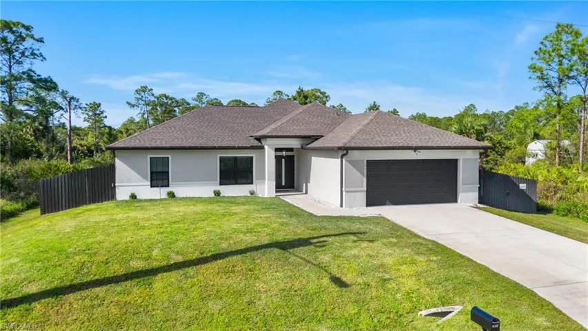 View of front of property featuring a front lawn and a garage