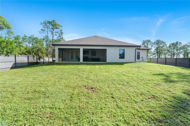 Back of property featuring a lawn and ceiling fan