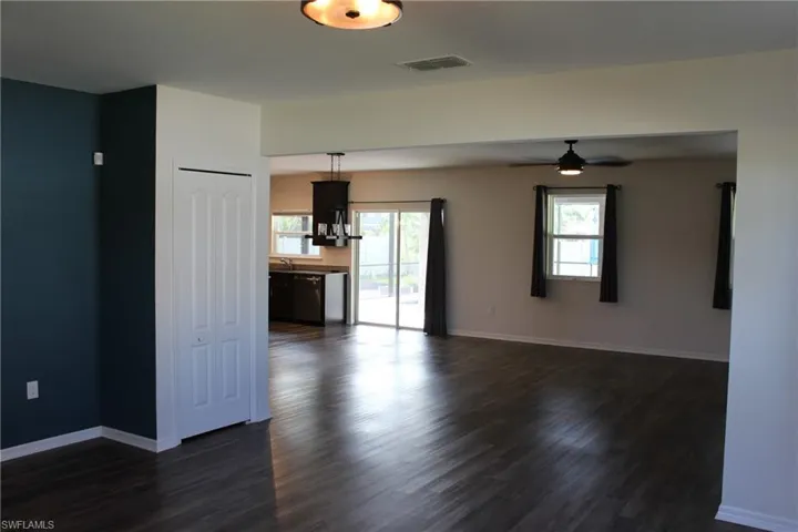 Unfurnished living room featuring dark vinyl flooring and ceiling fan
