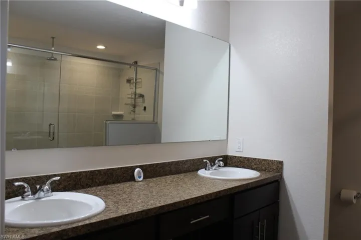 Bathroom with a shower with door and double sink vanity