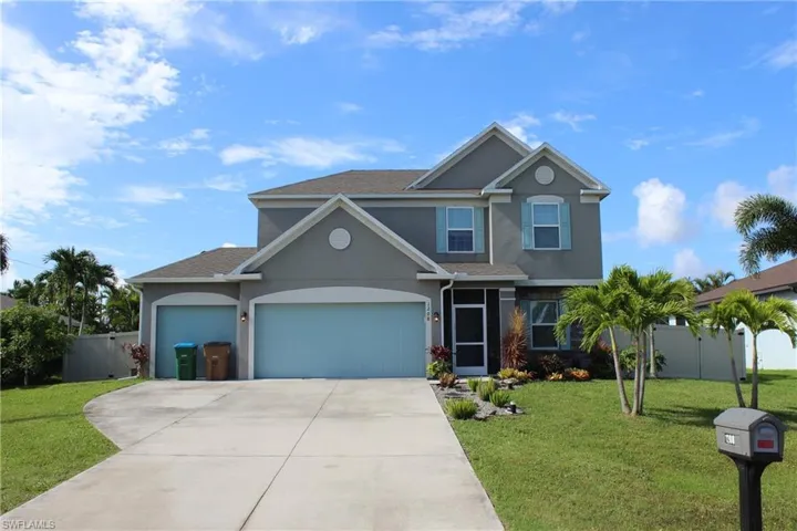 View of front of property featuring a garage and a front lawn