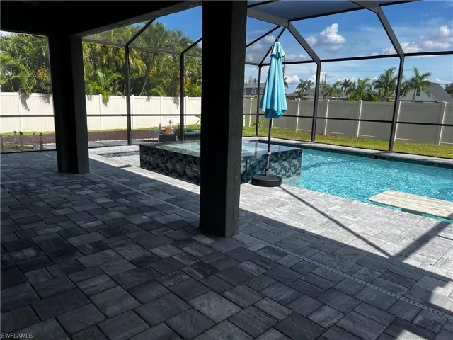 View of swimming pool featuring a patio and a lanai