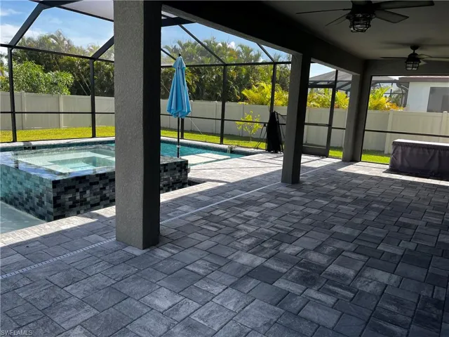 Unfurnished sunroom with a pool and ceiling fan