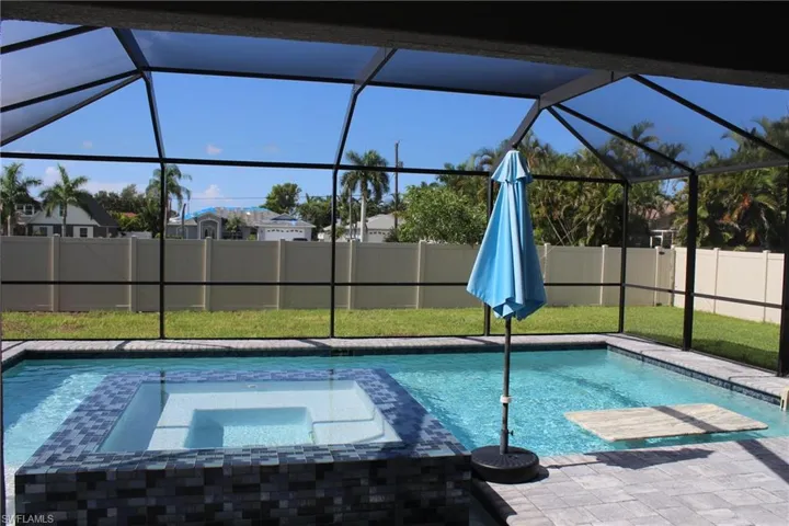 View of pool featuring an in ground hot tub and glass enclosure