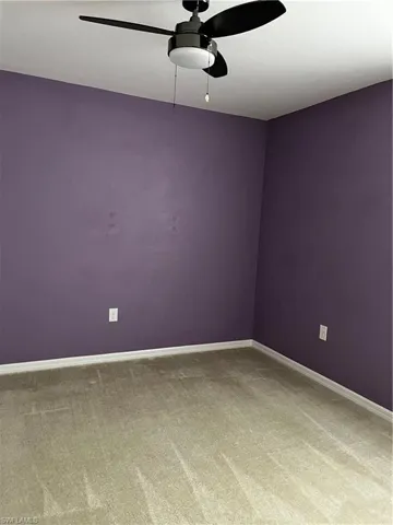 Empty room with ceiling fan and carpet flooring