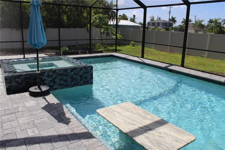 View of swimming pool with an in ground hot tub and a lanai